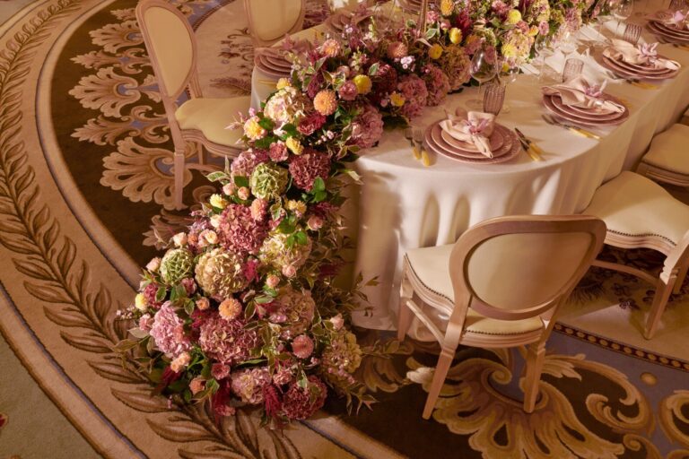 A table dressed with a garland of roses and hydrangeas and pink place settings, The Dorchester