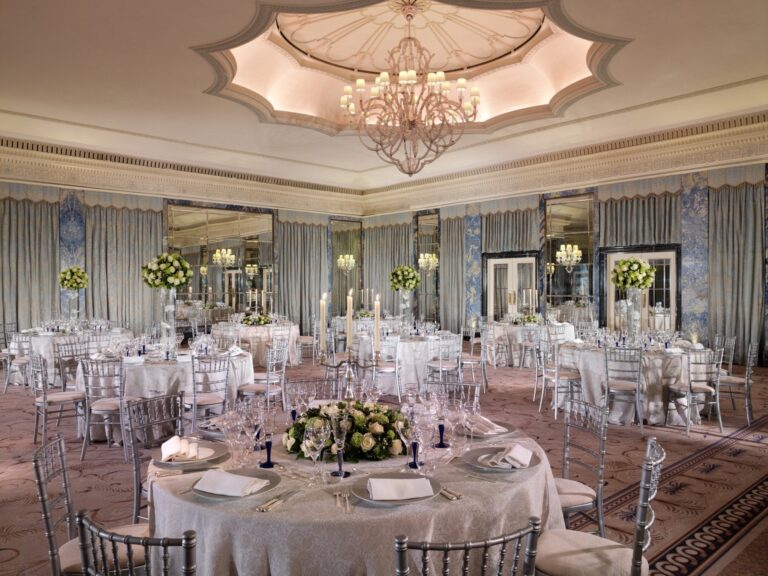 The Ballroom laid for dinner with silver chairs, white flowers and a domed chandelier, The Dorchester