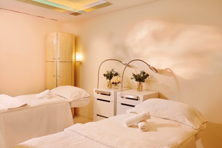 A twin treatment room at The Dorchester Spa with two beds and soft lighting, The Dorchester