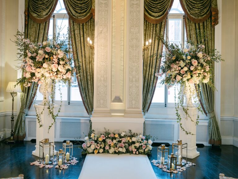 Floral arrangements on pedestals and lanterns at the end of a white aisle, The Lansdowne Club
