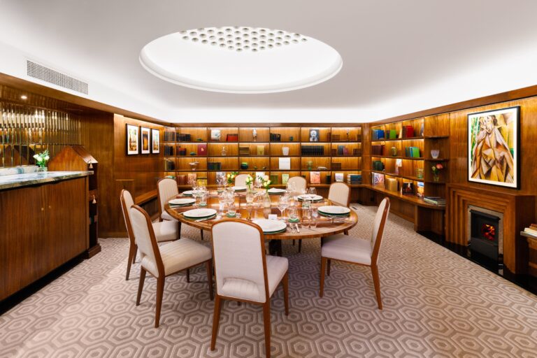 The Library private dining room, a round table surrounded by lit bookshelves, The Lansdowne Club
