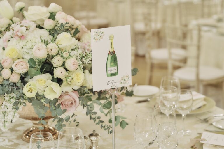 A centrepiece of white and pink roses with a Champagne-bottle table card, The Lansdowne Club