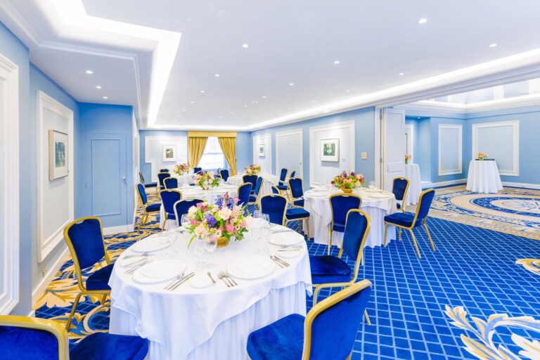 The Shelburne Room laid with round tables, blue chairs and flowers, The Lansdowne Club