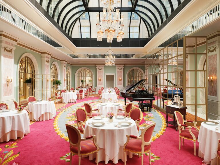 The Ritz Restaurant under a glazed roof, with a grand piano and red and gold carpet, The Ritz London