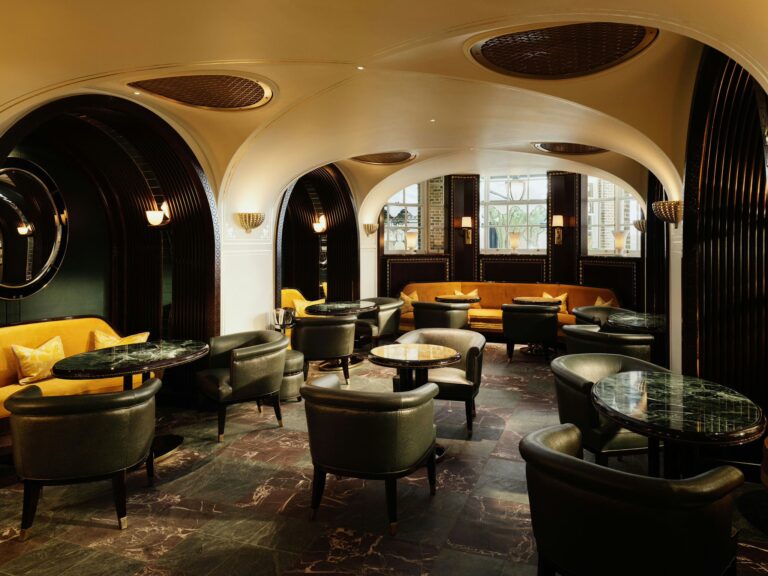 A bar room with curved arches, leather armchairs and low tables, The Ritz London