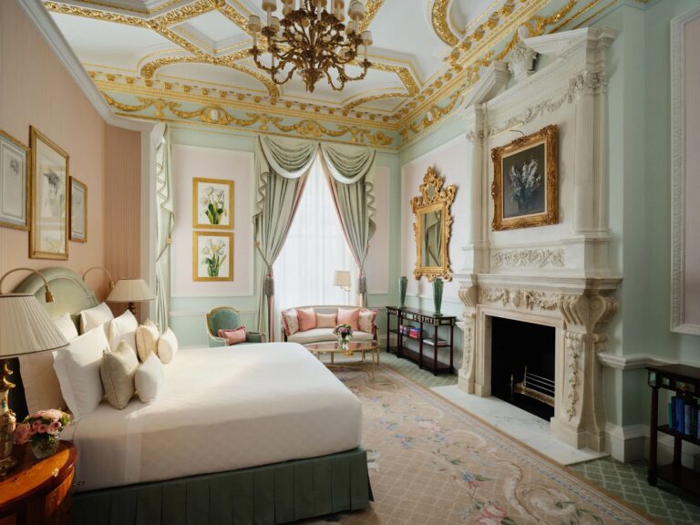 A bedroom in the Burlington Suite with a marble fireplace and gilded ceiling, The Ritz London