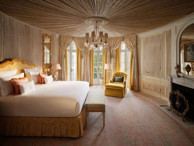 The Royal Suite bedroom, with a draped ceiling, chandelier and gilded bed, The Ritz London