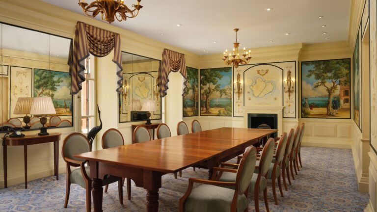 A long dining table in a room painted with Venetian murals, The Savoy