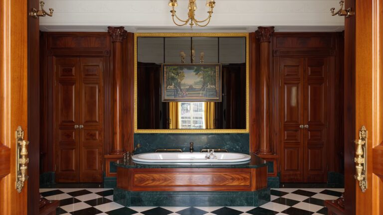 A Royal Suite bathroom with a sunken bath, wood panelling and a chequered marble floor, The Savoy
