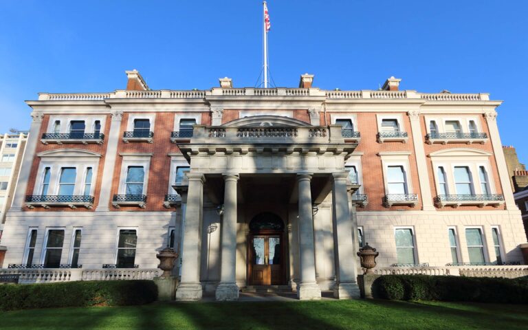The brick and stone front of Hertford House, with its columned porch and a flag on the roof, The Wallace Collection