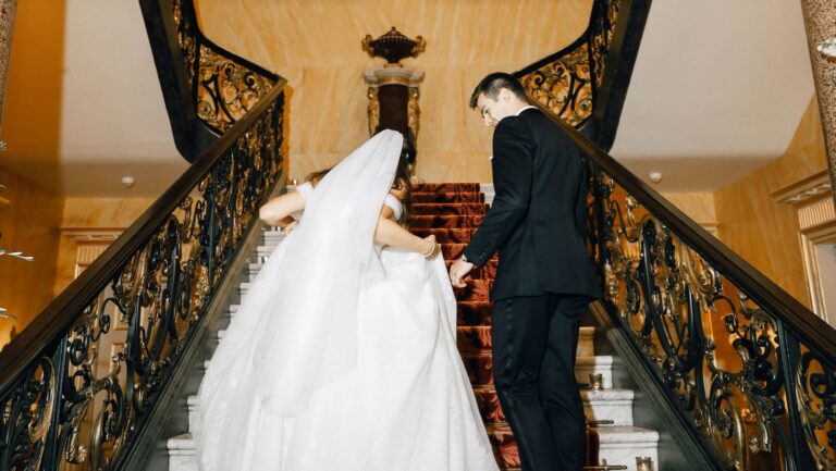 A bride and groom climbing a marble staircase with an ornate gilt balustrade, The Wallace Collection
