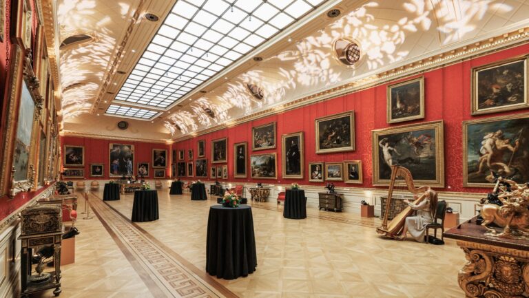 Standing tables set out for a reception in a long gallery under a lit skylight, The Wallace Collection