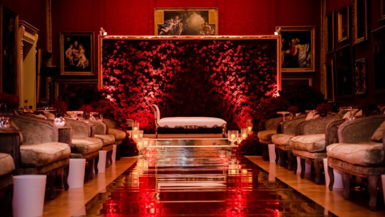 Velvet sofas arranged before a wall of red flowers in a red-walled gallery, The Wallace Collection