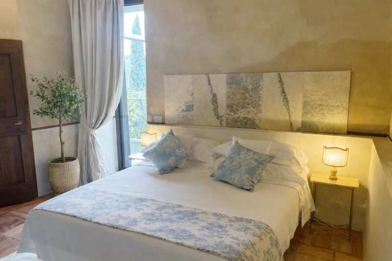 The Donizetti room with its stone-slab headboard, toile cushions and a garden window, Torre Collevento