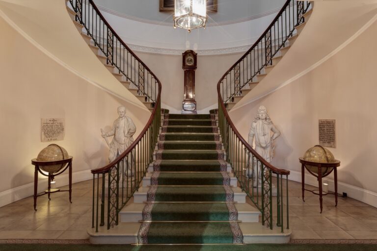 Samuel Wyatt's twin curved staircase with a longcase clock, marble statues and a pair of globes, Trinity House on Tower Hill