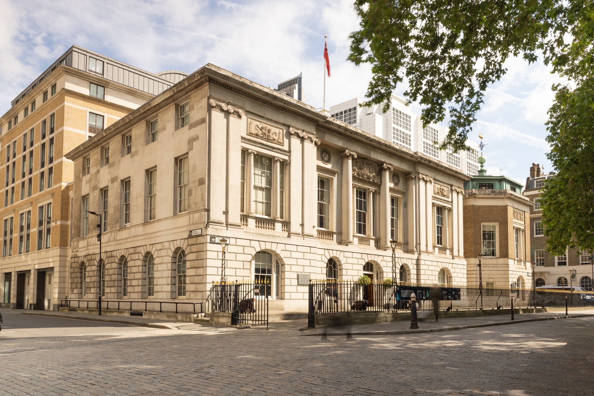 The Portland stone front of Trinity House on the corner of Trinity Square, behind its railings and cobbled forecourt, Trinity House on Tower Hill