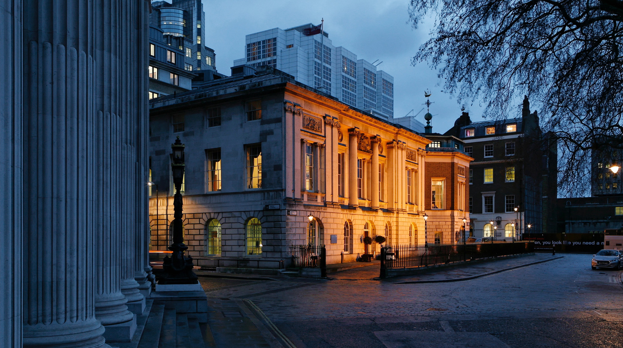 Trinity House lit at dusk, seen past the columns across Trinity Square, Trinity House on Tower Hill