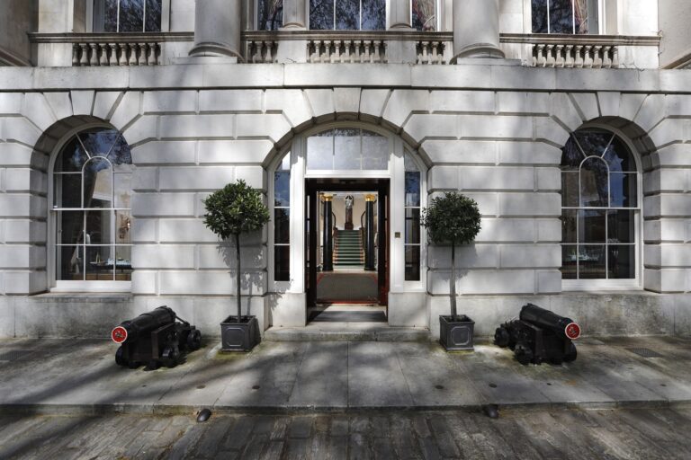The arched front entrance flanked by bay trees and a pair of cannons, looking through to the staircase, Trinity House on Tower Hill