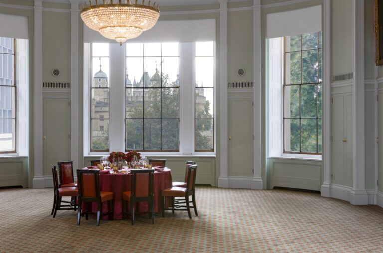 A single table in the Library bay, with the Tower of London framed in the windows, Trinity House on Tower Hill
