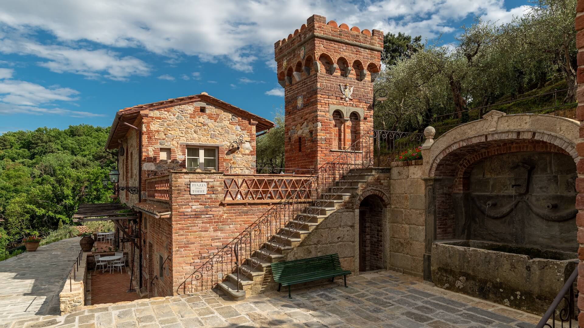 A red-brick tower and stone stairway in the upper part of the borgo, Valle di Badia