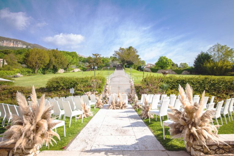 Chairs and pampas grass set for a ceremony in the Parco della Pieve, below the stone staircase, Villa Cariola