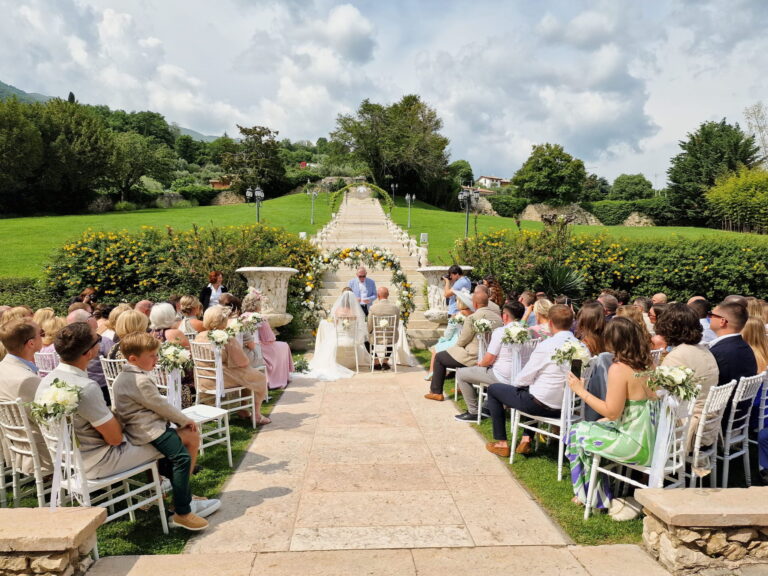 Guests seated on the lawn for an outdoor ceremony at the foot of the garden staircase, Villa Cariola