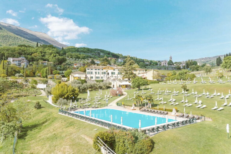 The outdoor pool and sunbeds in the park below the villa, with Monte Baldo behind, Villa Cariola