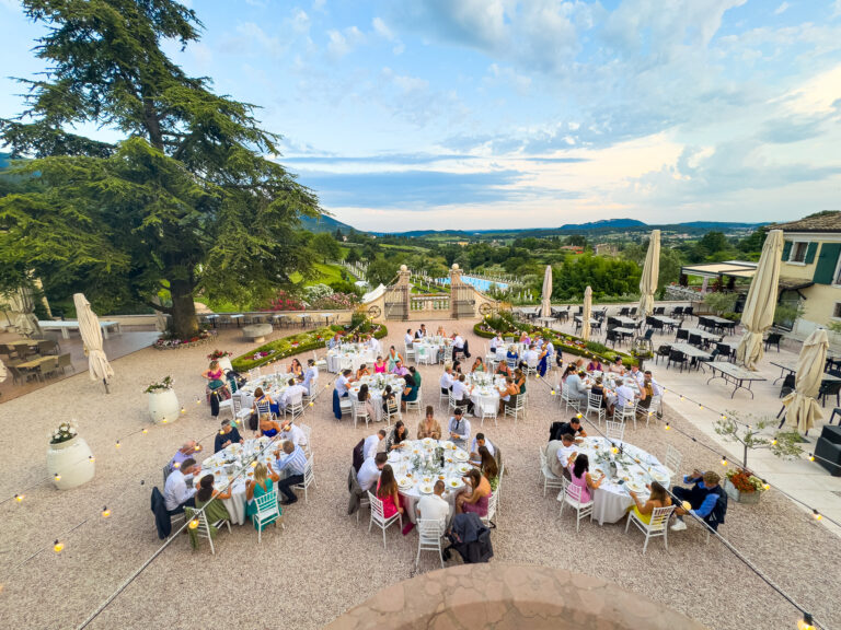 Guests at round tables on the panoramic terrace, with the valley and hills beyond, Villa Cariola