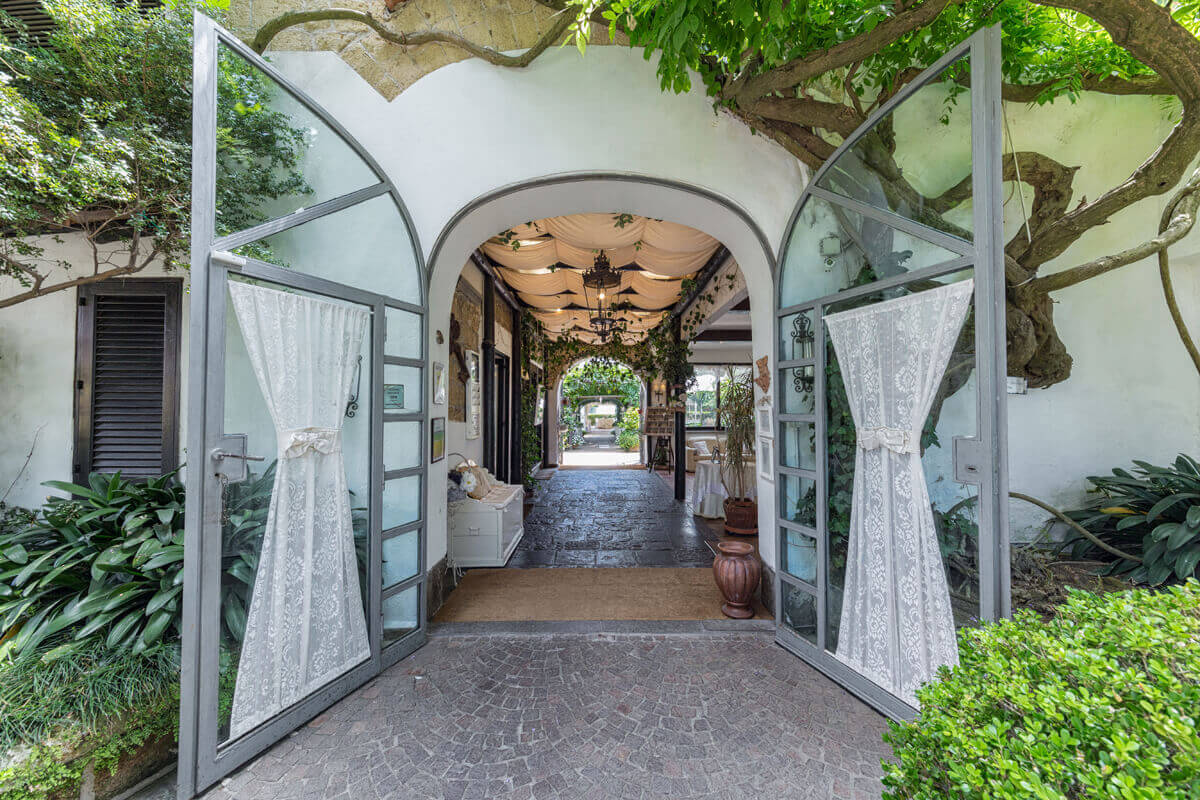 Glazed doors open onto the arched entrance passage, with the garden beyond, Villa del Vecchio Pozzo in Posillipo