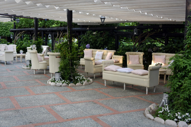 Sofas and armchairs grouped on the paved terrace under a shaded canopy, Villa del Vecchio Pozzo in Posillipo