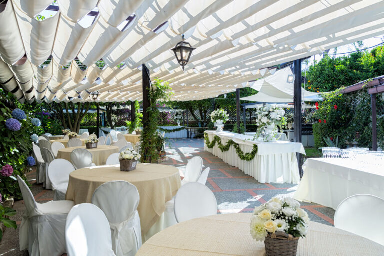Round tables and a buffet under the white awnings of the terrace patio, Villa del Vecchio Pozzo in Posillipo