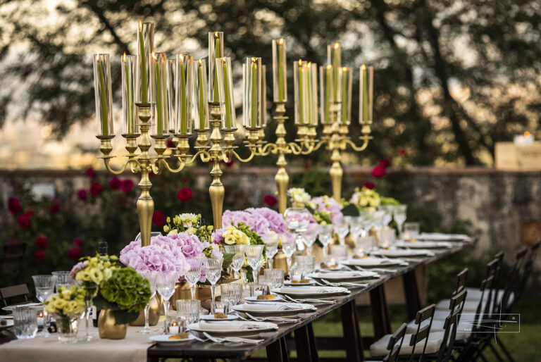 Gold candelabra and pink hydrangeas on a long outdoor dinner table, Villa Il Cerretino