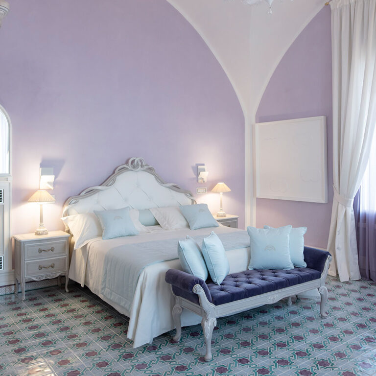 A vaulted bedroom with a tiled ceramic floor and upholstered bed, Villa La Rondinaia