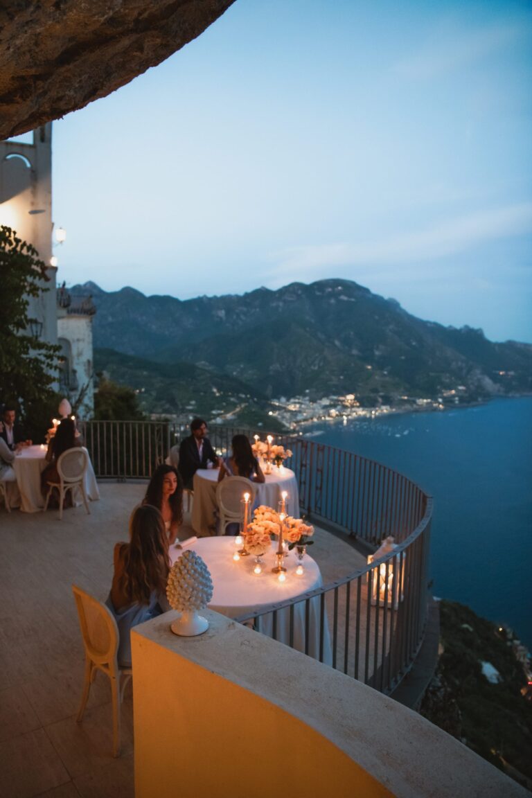 Candlelit tables on the terrace at dusk, looking along the coast, Villa La Rondinaia