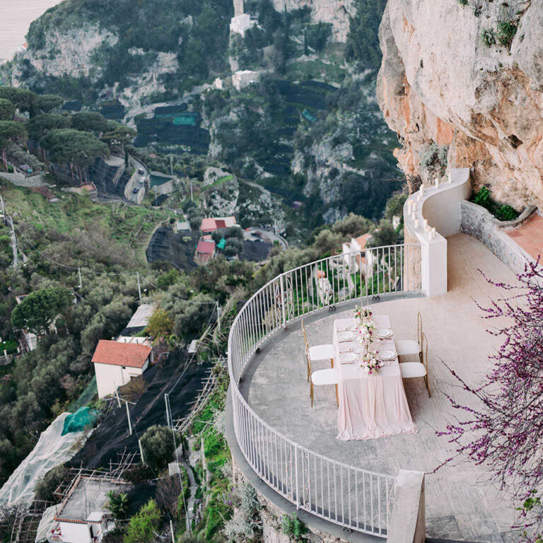 A long table laid on a round terrace above the cliffs, Villa La Rondinaia