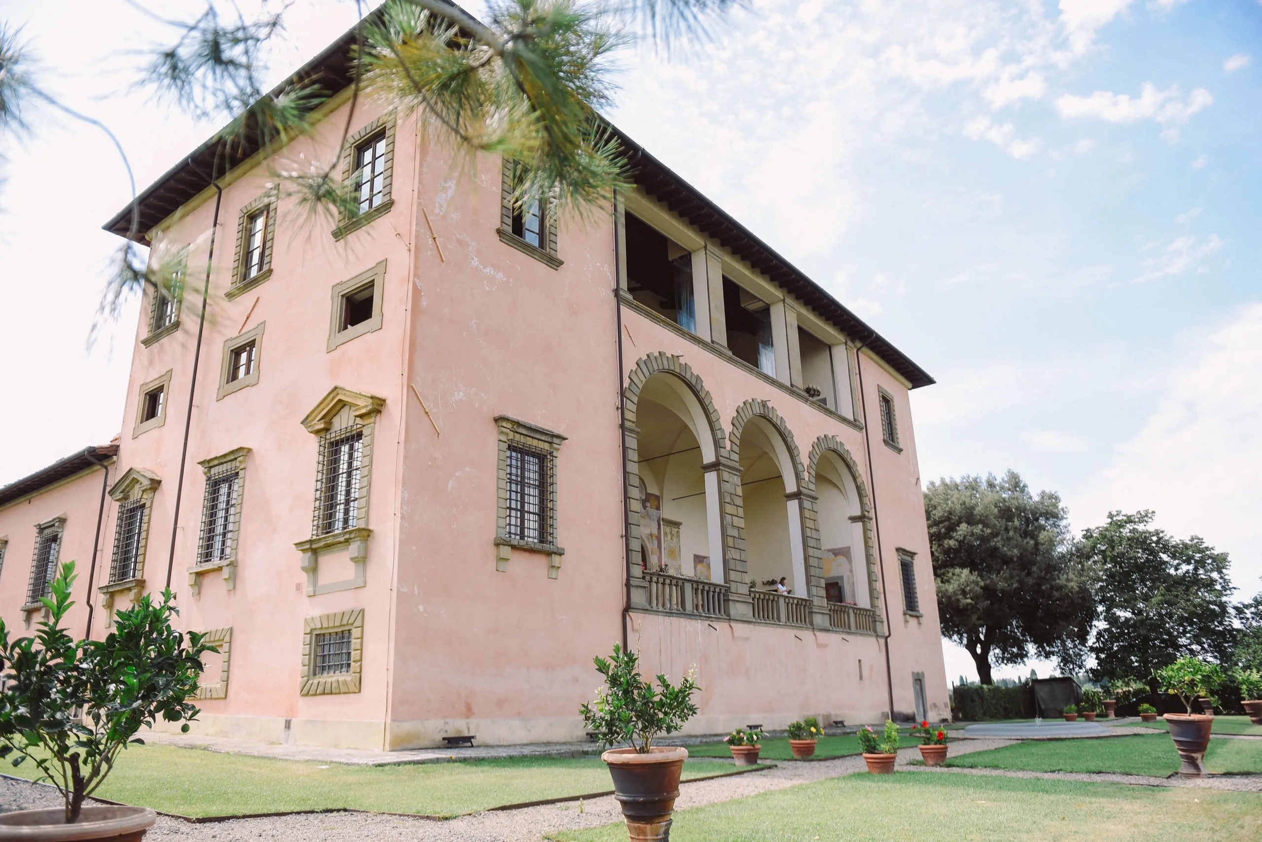 Pink Renaissance facade of Villa Mangiacane with arched loggias and potted lemon trees
