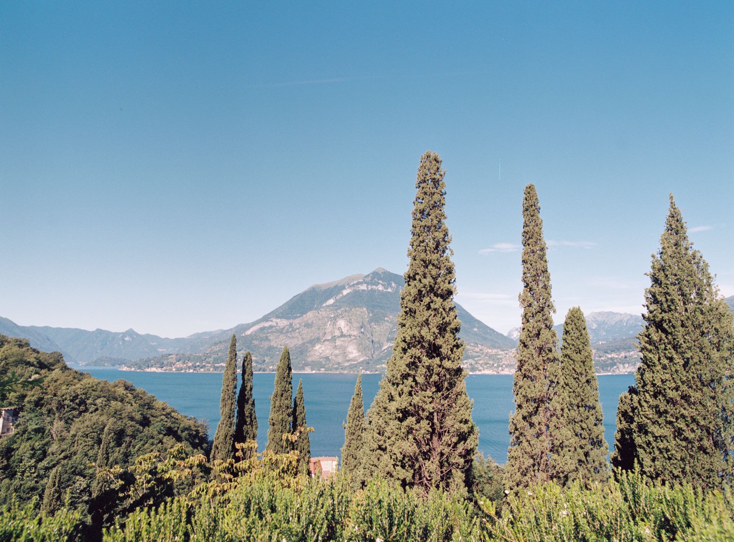 Cypresses in the garden framing the lake and the far shore, Villa Nascosta