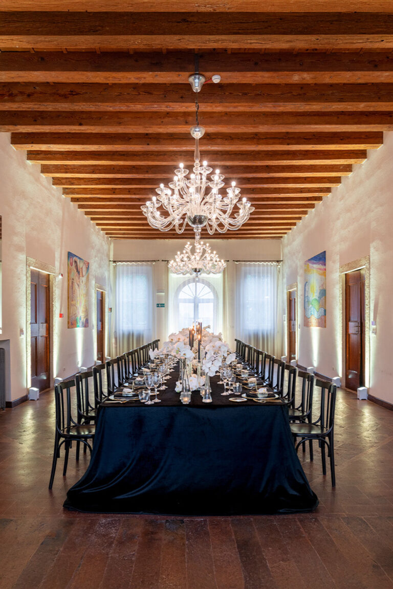 A single long table set for dinner down the length of the villa's beamed hall, Villa Ormaneto