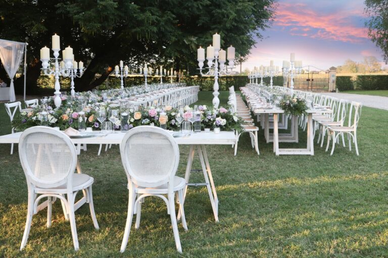 Long tables with candelabra and flowers on the lawn at sunset, Villa Ormaneto