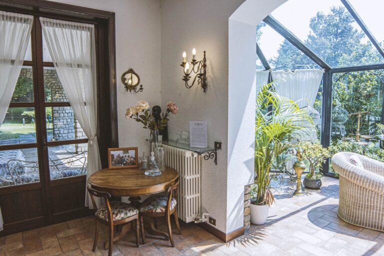 A sitting corner with a round table, opening into the glass veranda, Villa Sofia