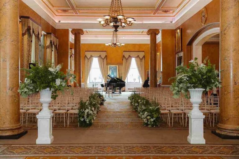 The Carlton set for a ceremony, floral pillars lining the aisle to the grand piano, 116 Pall Mall