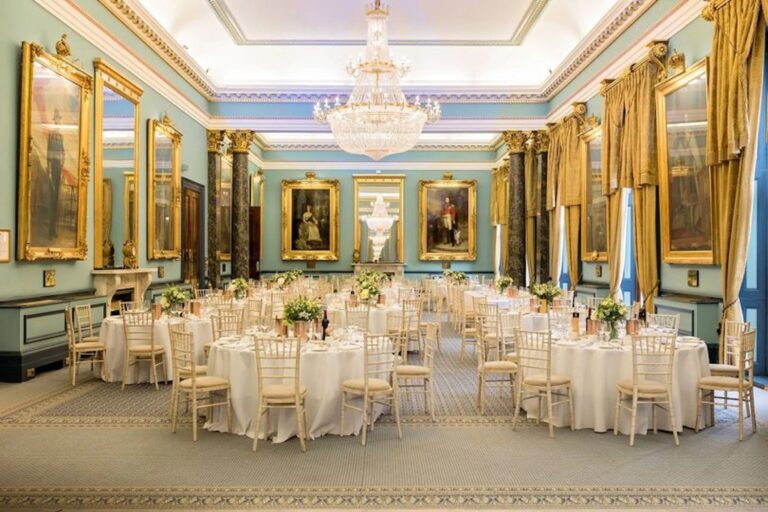 The Nash dressed for a wedding breakfast, round tables beneath chandeliers and royal portraits, 116 Pall Mall