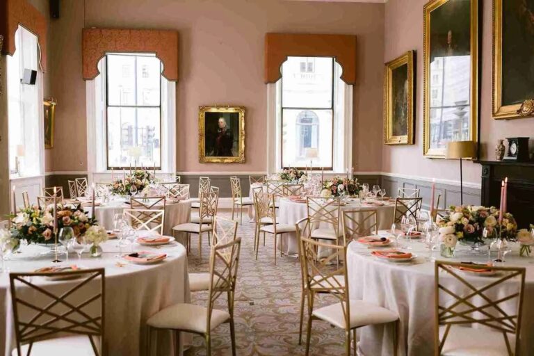 A light reception room dressed for a wedding breakfast, gold chairs and low florals, 116 Pall Mall