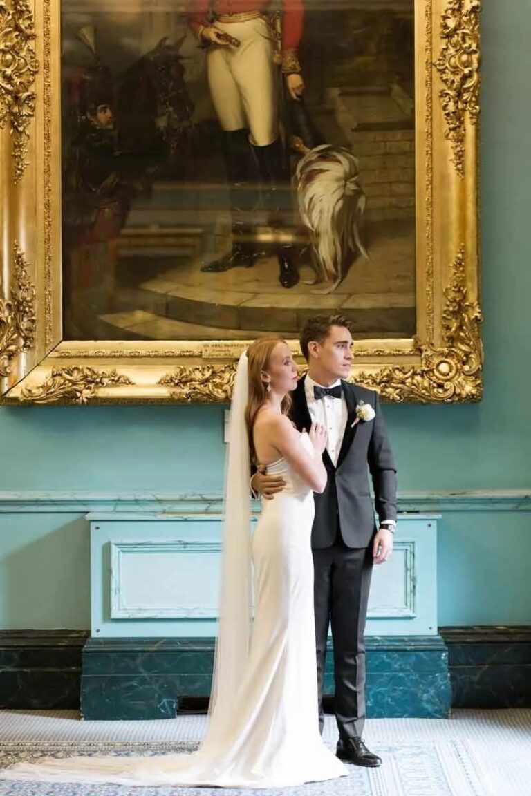 The couple beneath a gilt-framed portrait in the blue drawing room, 116 Pall Mall