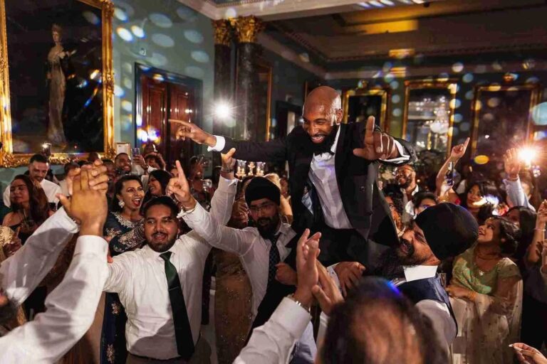 Guests lifting the groom during the evening celebration, 116 Pall Mall