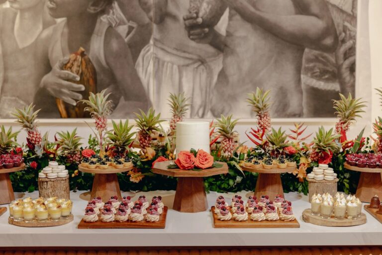 Dessert table with tropical flowers and a white cake in Cartagena, 5th Avenue Weddings