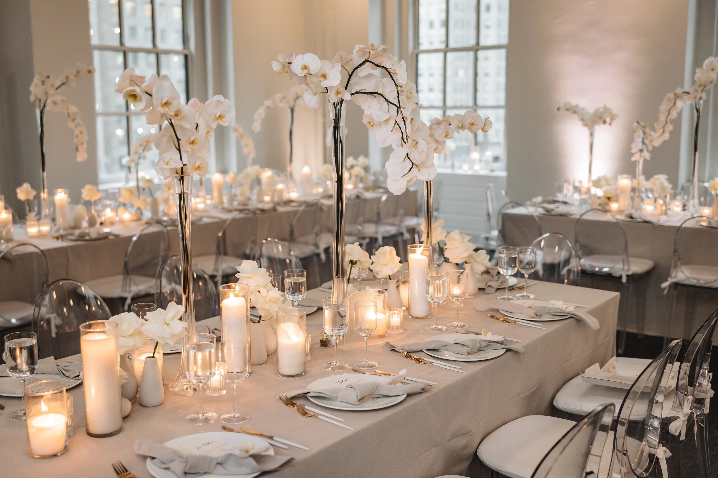 Long tables with white orchids and candles in a light-filled Manhattan loft, 5th Avenue Weddings