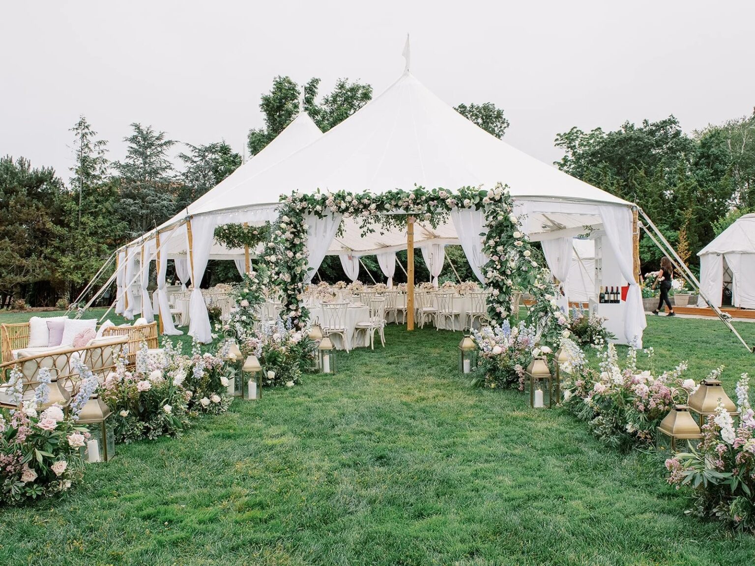 White tent with a flower-draped entrance on a lawn at a Newport wedding, 5th Avenue Weddings