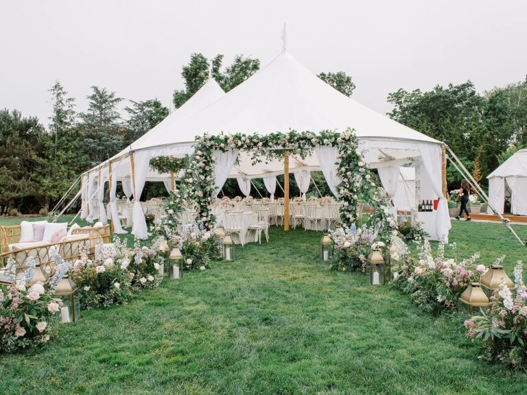 White tent with a flower-draped entrance on a lawn at a Newport wedding, 5th Avenue Weddings