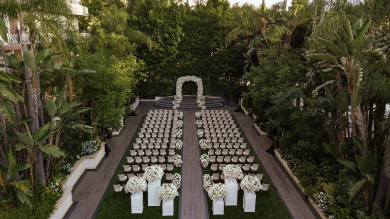 Aerial view of a hedge enclosed garden ceremony with white aisle flowers, About Details Details